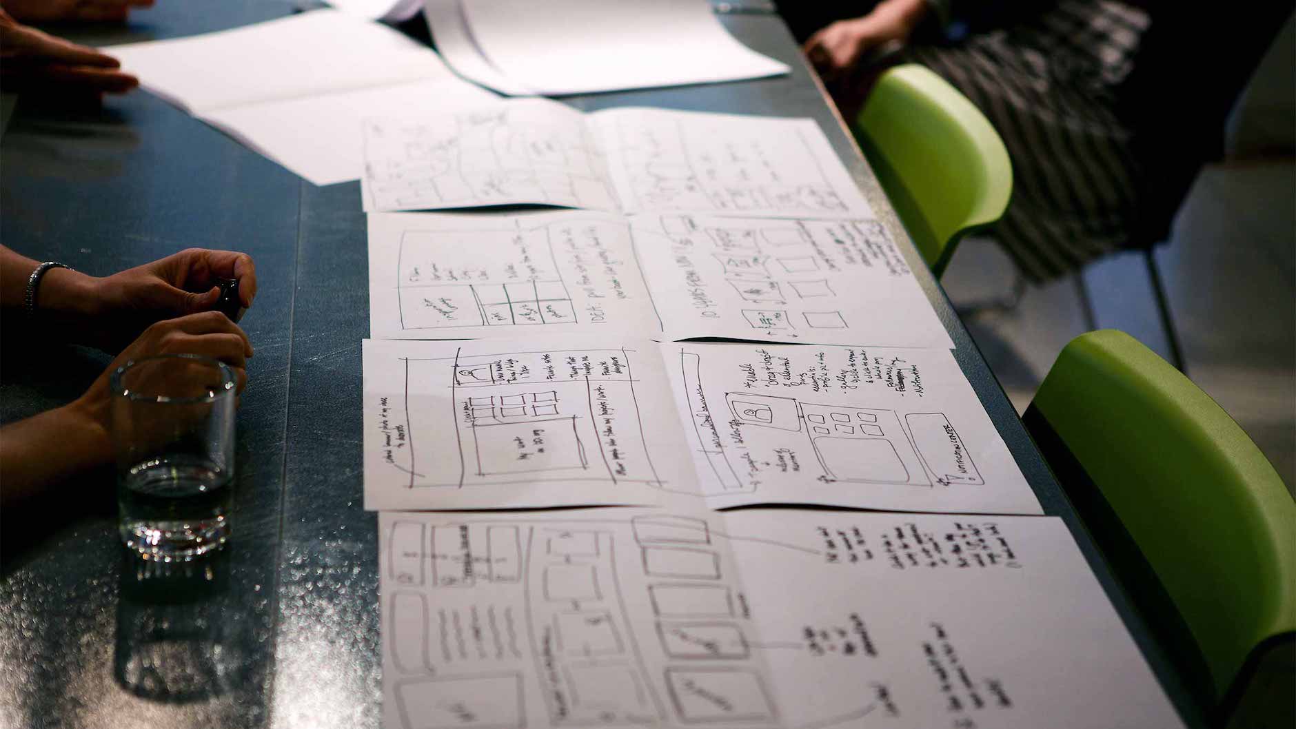 A collection of sketches lined up on a desk to illustrate information architecture in UX design