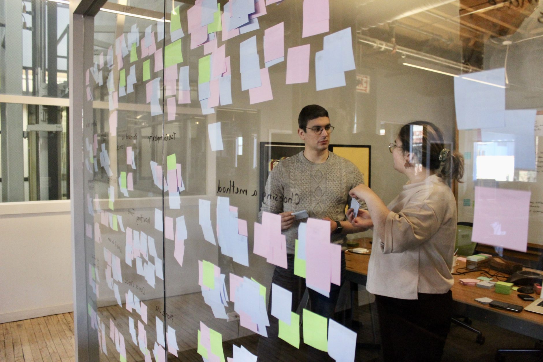 Two people synthesizing enterprise software UX design research